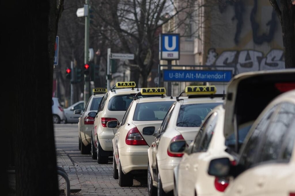 Une rangée de taxis beige attend devant un panneau U-Bahn