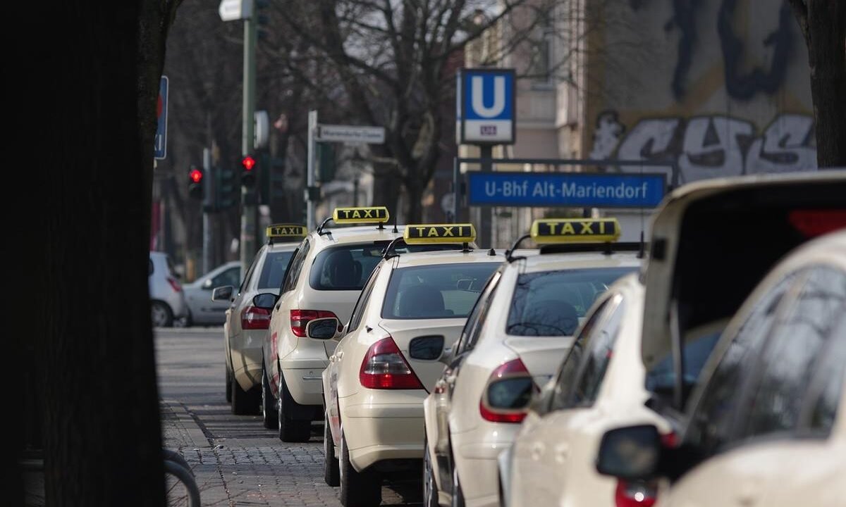Une rangée de taxis beige attend devant un panneau U-Bahn