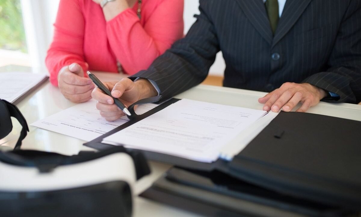 Deux personnes signant des documents à une table de bureau