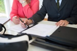 Deux personnes signant des documents à une table de bureau