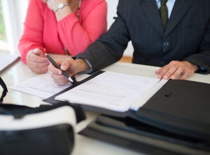 Deux personnes signant des documents à une table de bureau