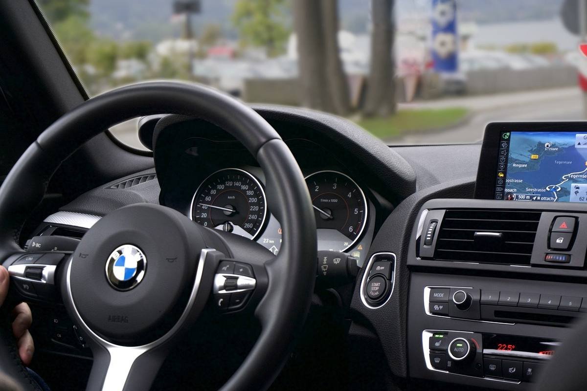 Vue du cockpit d'une BMW, volant, compteurs, écran GPS allumé