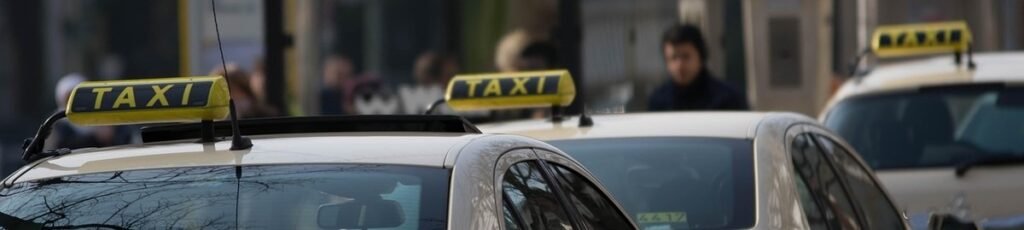 Des taxis jaunes avec panneaux 'TAXI' stationnés dans la rue