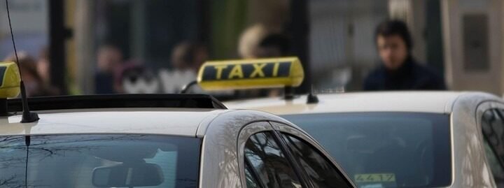 Des taxis jaunes avec panneaux 'TAXI' stationnés dans la rue