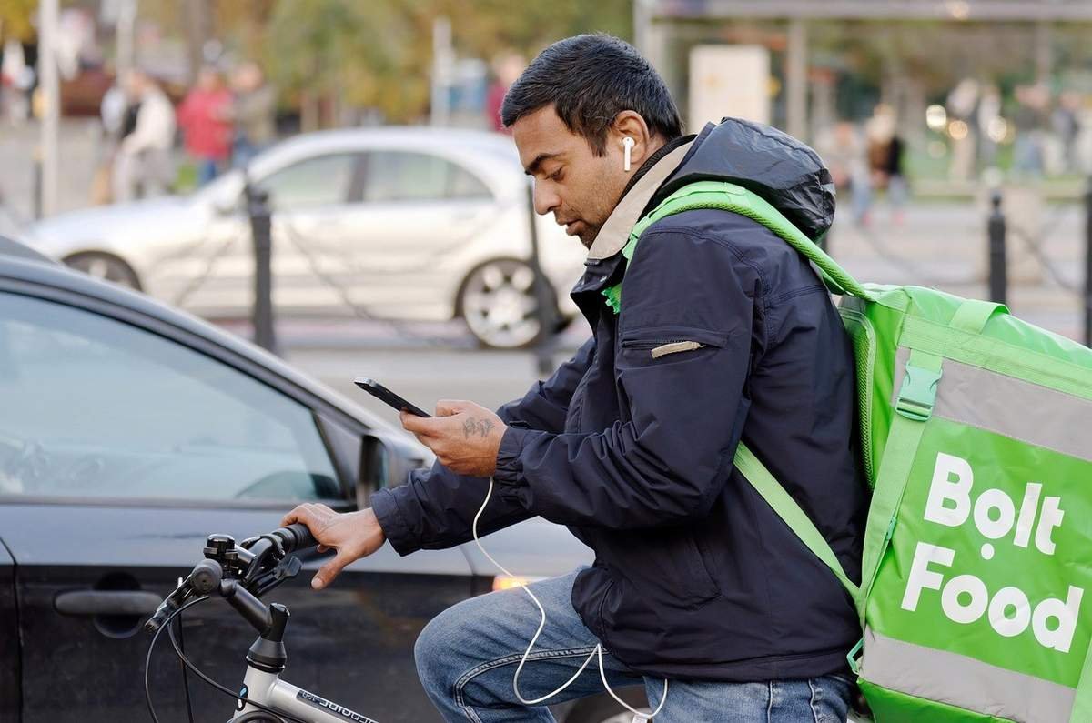 Homme cycliste avec téléphone et sac Bolt Food, en ville