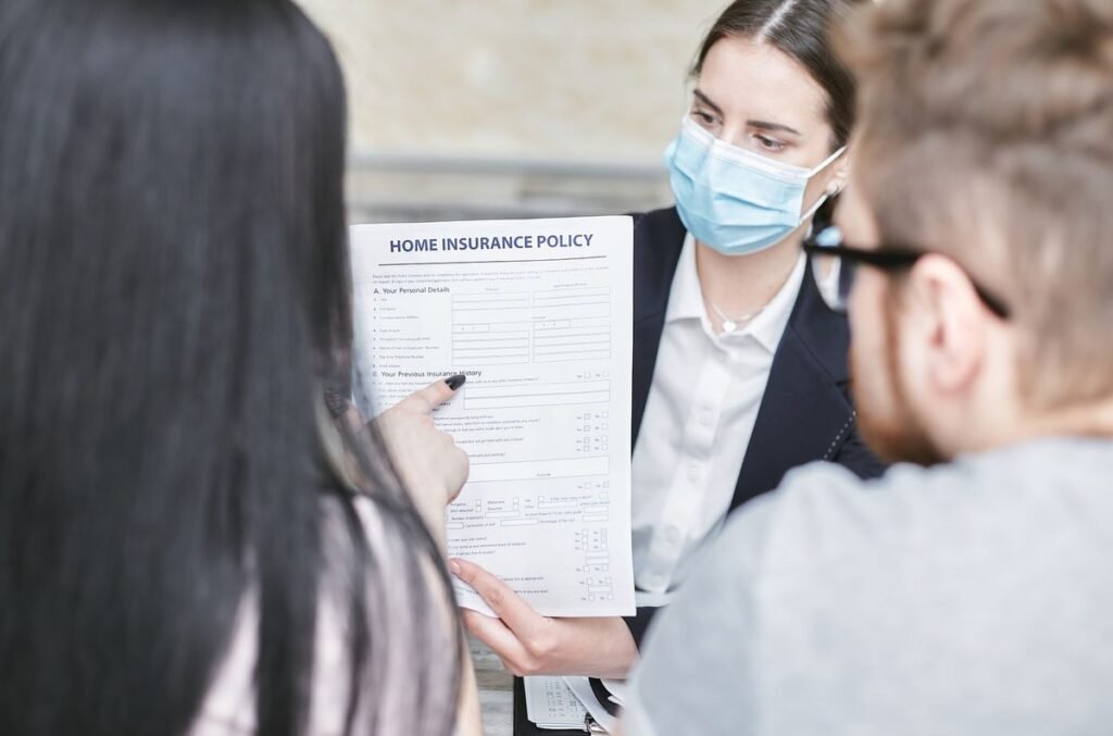 Une femme en masque montre un document d'assurance à deux clients
